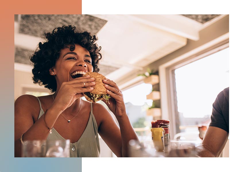 Happy woman eating a burger